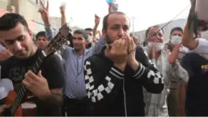 Man with microphone ahead of crowd